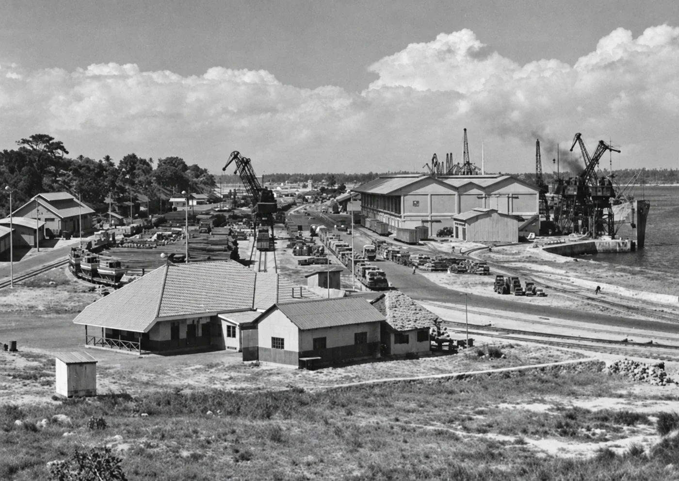 Enhanced archival photograph of cranes, railway tracks and warehouses at Kilindini Harbour